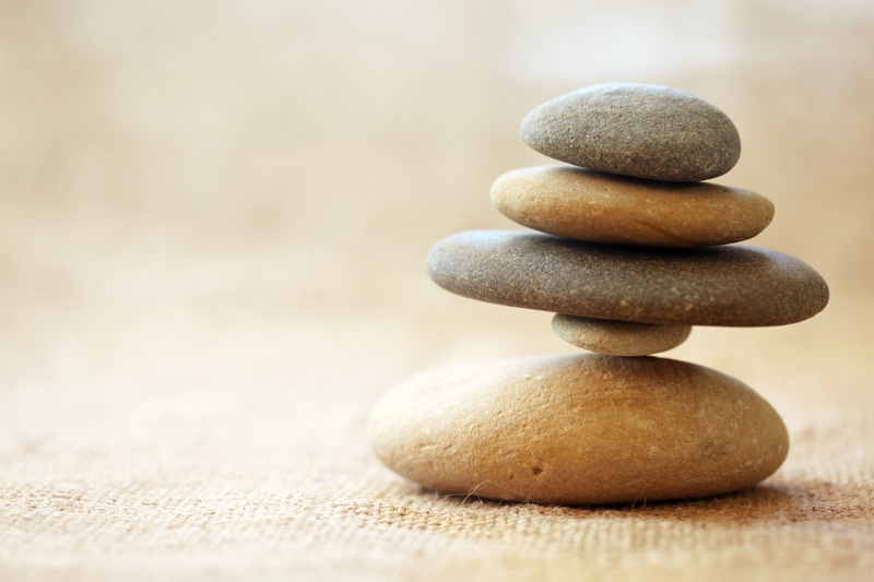 Piedras apiladas en equilibrio sobre una superficie de tela clara
