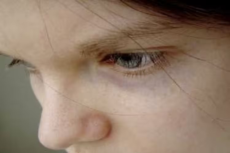 Primer plano del rostro de una mujer con la mirada baja